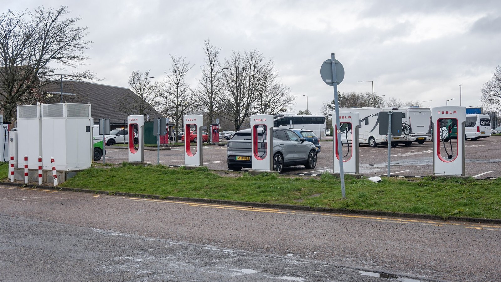 Public rapid EV chargers with a car plugged in at a charging hub